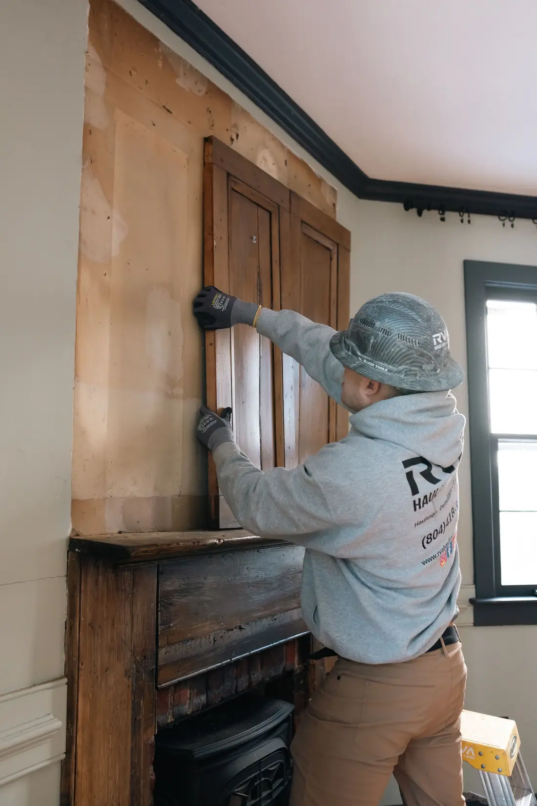 Worker assessing a wall surface before demolition begins