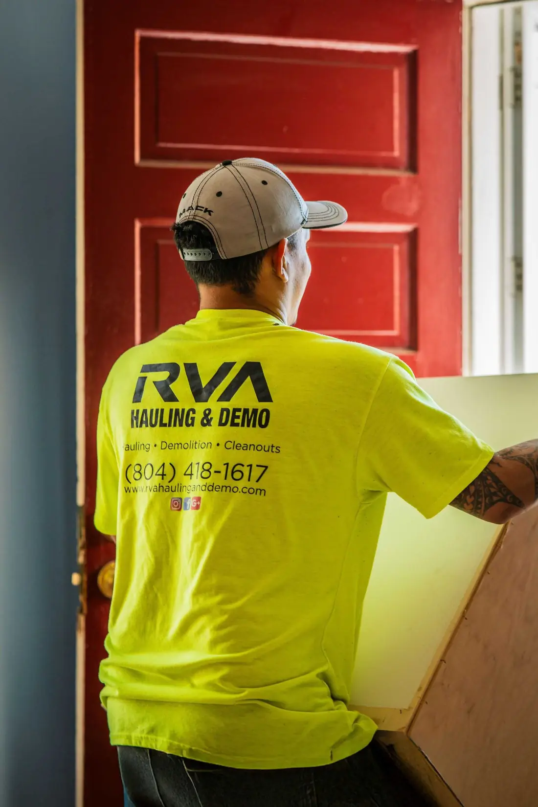 Worker in gray clothes drilling into a wall inside an unfinished room